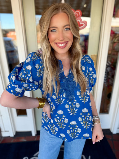Floral top with puff sleeves and detailing along the v neckline